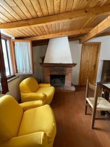 阿贝托内Discovering Apartments Abetone的客厅设有黄色沙发和壁炉