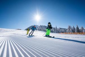 塞博登Pension Linder的三人在雪覆盖的斜坡上滑雪
