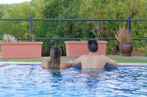 El Rosario芬卡拉马加德拉酒店的坐在游泳池里的男人和女人