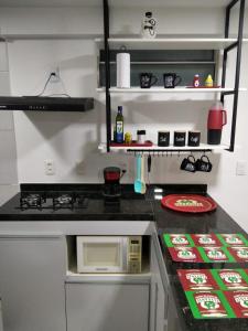 莫索罗Apartamento em Nova Betânia - West Flat Mossoró的厨房配有炉灶和微波炉。