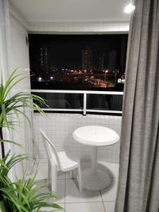 莫索罗Apartamento em Nova Betânia - West Flat Mossoró的阳台上配有白色的桌椅和窗户