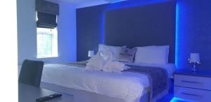 克利夫罗The Avenue Hotel Ltd的蓝色卧室,配有带毛巾的床