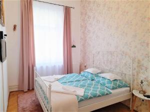 赛特古特哈德D16 Apartman的卧室配有白色床、蓝色床单和窗户。