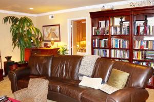 英格尔伍德Shared Home的客厅里设有一张棕色皮沙发,配有书架