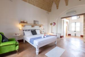 科尔萨诺La Torretta的一间卧室配有一张床和一把绿色椅子