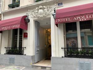 巴黎Hôtel Apollo Opéra的大楼内有两个红色遮篷的酒店入口