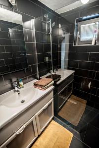 采列Apartment Dolce Vita的黑色瓷砖浴室设有水槽和镜子