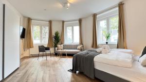 杜塞尔多夫Favorite Stays - Suite And More - 10 Min zur Messe的一间卧室配有一张床,客厅配有窗户