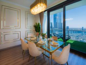 迪拜WORLD CLASS 3BR with full BURJ KHALIFA and FOUNTAIN VIEW的一间带桌椅和大窗户的用餐室