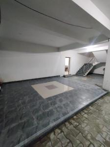 钦奈Allamanda Abode的一间空房间,设有石地板和楼梯