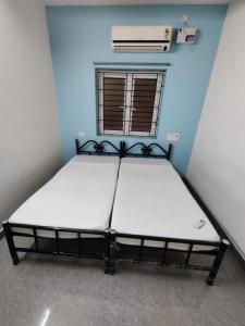 钦奈Allamanda Abode的蓝色客房中一间带床的卧室