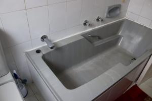 约翰内斯堡Bougainvillea at Boskruin的浴室内设有带水龙头的白色浴缸