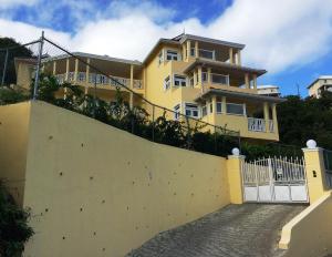 Cap Estate南海公寓的前面有白色围栏的黄色房子