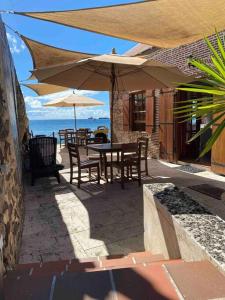 奥拉涅斯塔德Barrel House Suite St Eustatius的一个带桌椅和遮阳伞的庭院