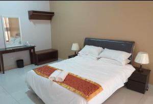 拉布安Labuan Paragon Apartment - 3 rooms的一间卧室配有一张大床和两条毛巾