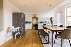 伦敦The Clapham Dream - Captivating 3BDR with Garden & Parking的厨房以及带桌椅的用餐室。