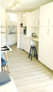 伊索拉Isola 2000 pied des pistes-wifi的厨房铺有木地板,配有白色橱柜。