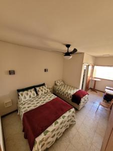 圣罗克迪米纳斯Canastra Eco Hospedagem的一间卧室配有两张床和吊扇