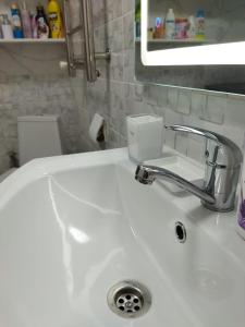 阿克套City House的白色浴室水槽和肥皂分配器