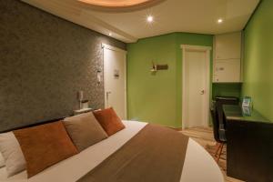 上克鲁斯帕拉迪索情趣酒店 - 克鲁斯阿尔塔的一间卧室配有一张带绿色墙壁的床和一张书桌