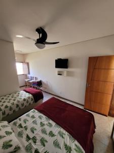 圣罗克迪米纳斯Canastra Eco Hospedagem的一间卧室配有两张床和吊扇