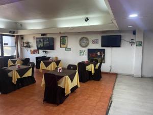 Lerma de VilladaHotel Lerma的一间设有两张桌子的房间,配有黄色和黑色桌布