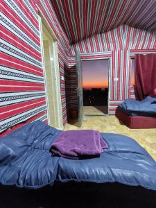 达纳Dana Sunset Eco Camp的一张位于带条纹墙的房间的床铺