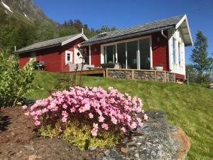 灵塞德Kjosen Lodge, Lyngen.的前面有粉红色花的房子