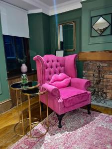 阿伯丁Historic Cottage in the Heart of Old Aberdeen.的客厅配有一张粉红色的沙发,配有一张桌子