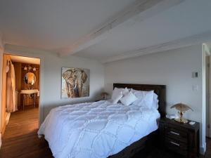 拉马巴耶维多利亚住宿酒店的卧室配有白色的床和墙上的绘画作品