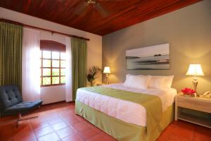 普拉亚埃尔莫萨德尔苏阿诺别墅酒店的卧室配有床、椅子和窗户。