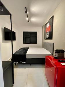 瓜鲁雅Acomodações Tio Will的一间卧室配有一张床和一张红色的书桌