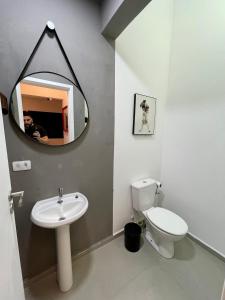 瓜鲁雅Acomodações Tio Will的一间带卫生间、水槽和镜子的浴室