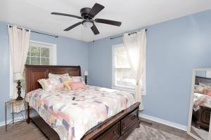 查尔斯顿Adorable Blue Little House的一间卧室配有一张带吊扇的床
