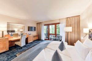 波恩波恩费努斯贝格多瑞特酒店的酒店客房设有一张大床和一张书桌。