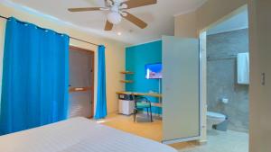 克拉伦代克松里萨精品酒店的一间卧室设有蓝色的墙壁和吊扇。