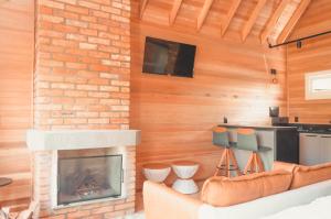 本图贡萨尔维斯Cabana Ouro do Vale - Nascer do Sol的客厅设有壁炉和沙发。