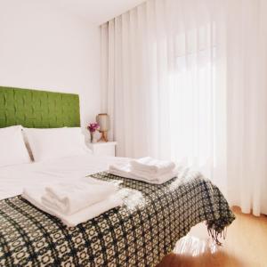 塞亚O 21 da Vila的一间卧室配有带毛巾的床