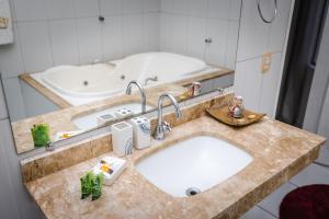南克鲁兹罗Hotel SPA Paraíso的浴室配有两个盥洗盆和浴缸。