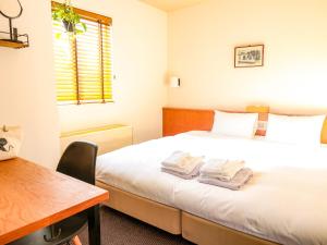 金泽金泽太平洋酒店的一间卧室配有一张床,上面有两条毛巾