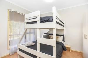 维克多港Kingsford Cottage - WIFI Pet Friendly的白色的客房内的一张白色双层床,配有一张床