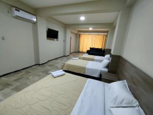 瓜亚基尔OCEANIk SUITES & HOTEL的酒店客房设有两张床和电视。