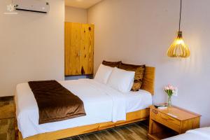 富国BB Hotel&Resort的卧室配有一张白色的大床和床头柜。