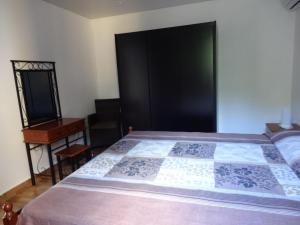 勒莫尔尼View on Ilot Fourneau的一间卧室配有一张带黑色门的床和一张书桌