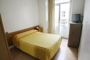 阿利坎特圣费尔南多旅馆 的一间卧室配有黄色的床和电视