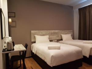 关丹列韦瑞吉莱特酒店（关丹）的酒店客房设有两张床、一张桌子和一张书桌。