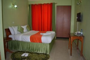埃尔多雷特Hotel Winstar的一间卧室配有一张带红色窗帘的床