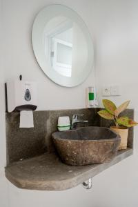 BatununggulThe Moon Hostel的一间带石制水槽和镜子的浴室
