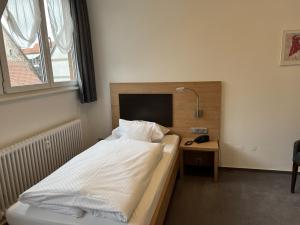 菲林根-施文宁根Hotel Bären的一间卧室配有一张床和一张带台灯的书桌
