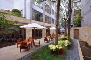 台北台北商旅-庆城馆的一个带桌椅和遮阳伞的户外庭院。